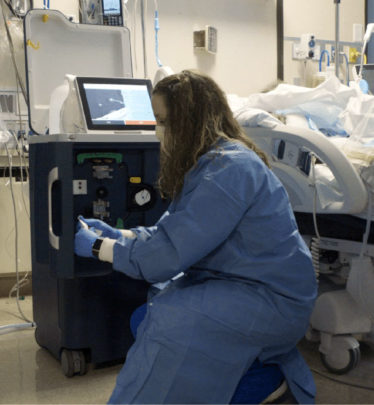 Nurse kneeling next to Tablo dialyzing in an ICU