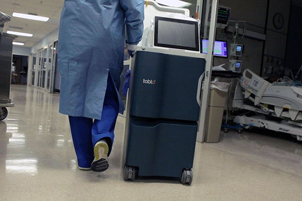 Nurse pushing Tablo dialysis machine