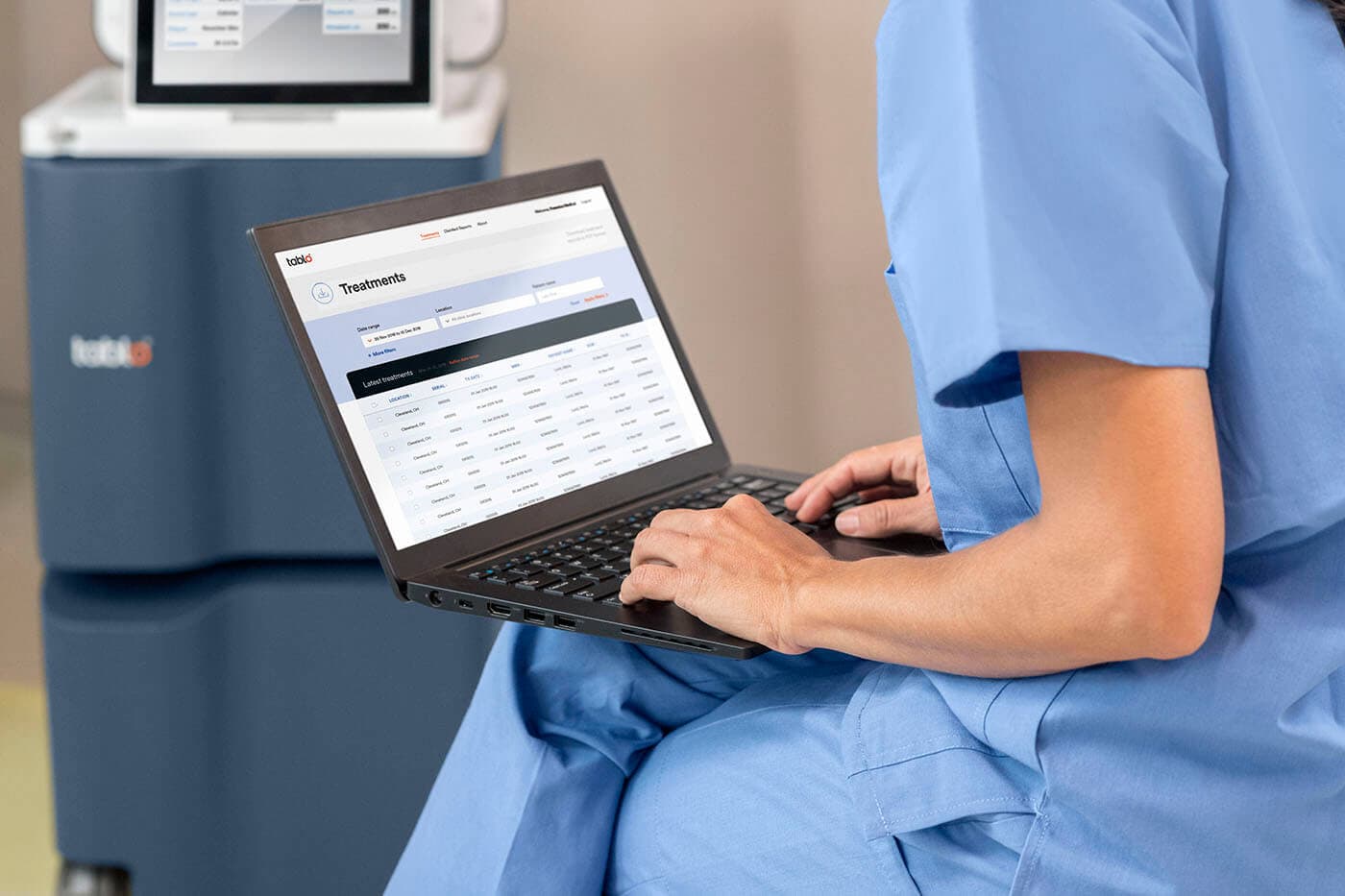 Nurse monitoring Tablo dialysis patients on laptop