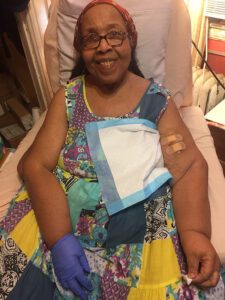 Woman sitting in a chair preparing for treatment on her Tablo Hemodialysis System