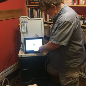 Man standing next to Tablo machine, preparing it for his wife’s home treatment