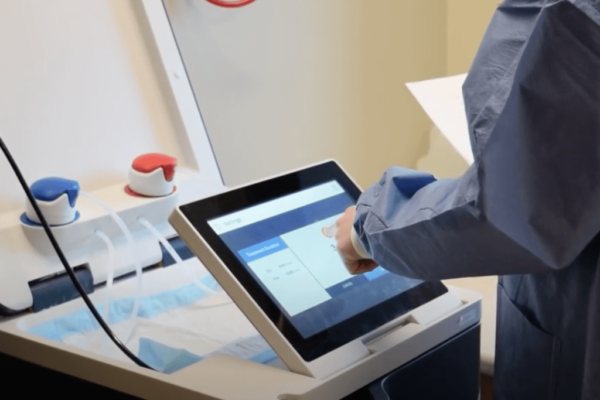A nurse uses Tablo's touch screen to adjust treatment settings
