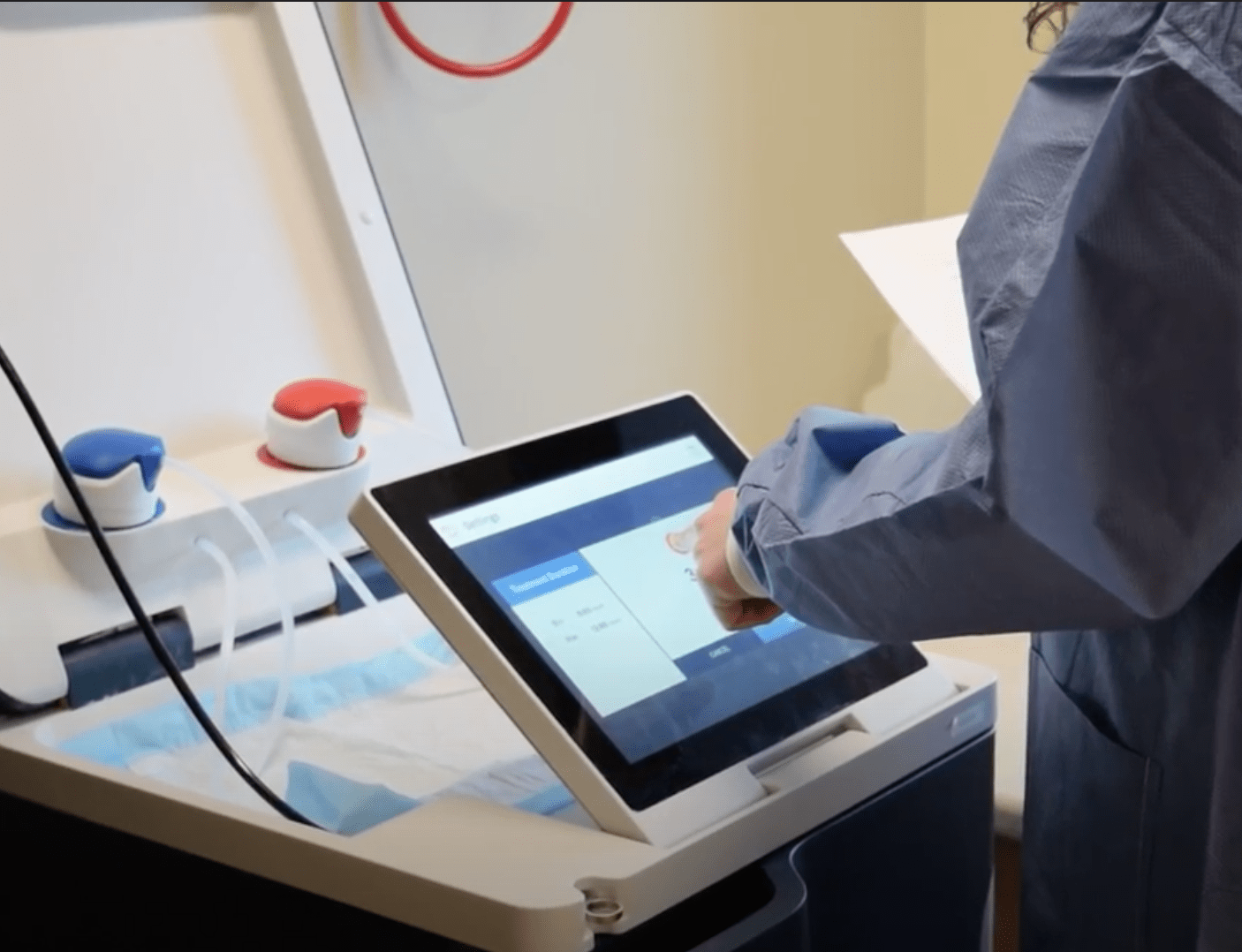 A nurse uses Tablo's touch screen to adjust treatment settings