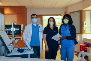 Three Stamford Health acute dialysis services professionals posing with a Tablo console